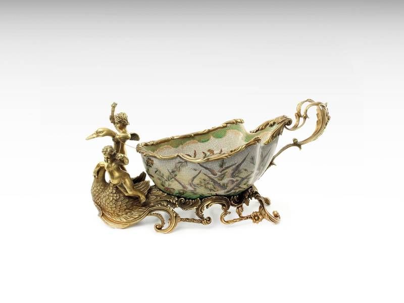 Taça de bronze e porcelana em forma de trenó com anjos querubins e cis